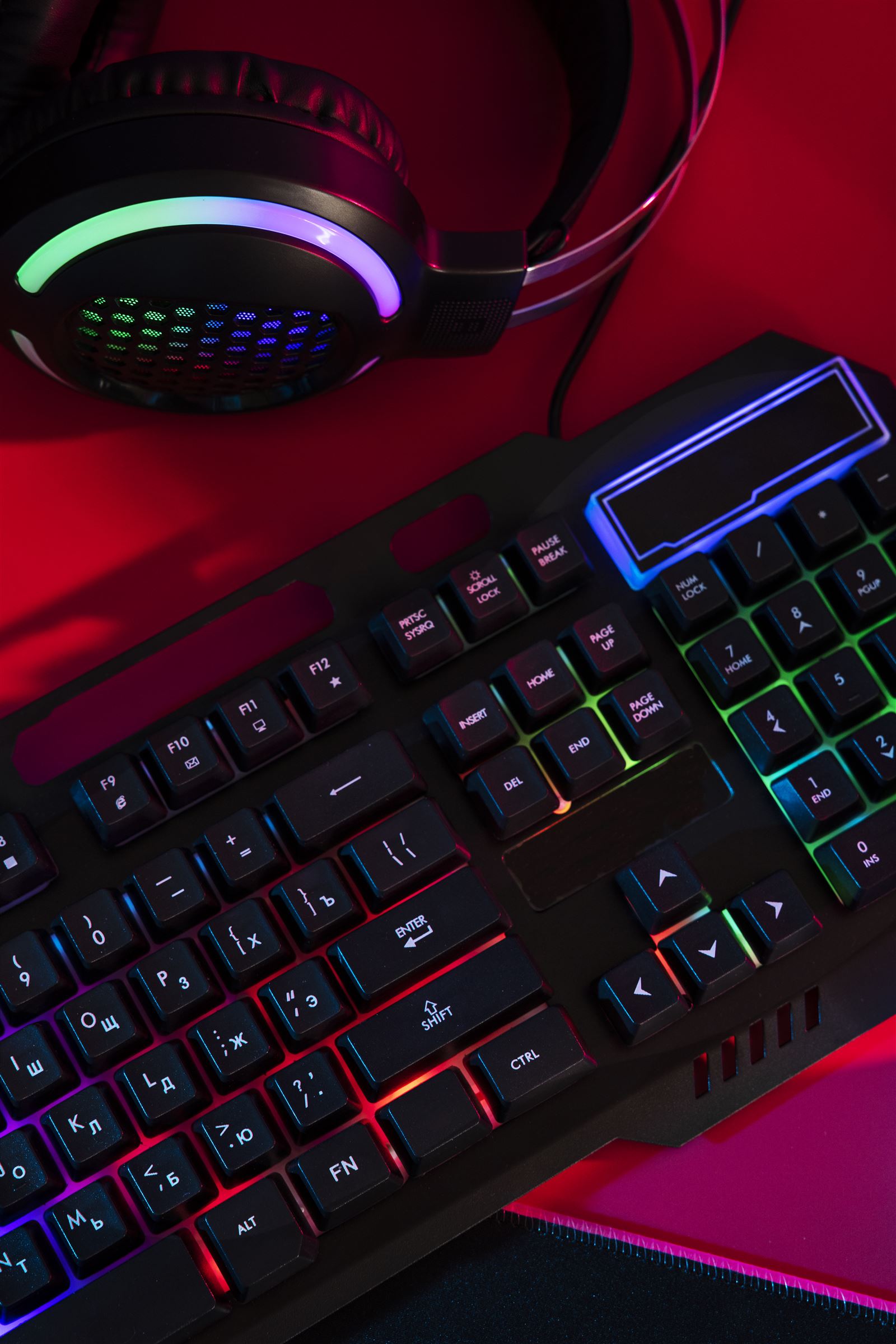 RGB gaming keyboard and headset on a neon-lit desk