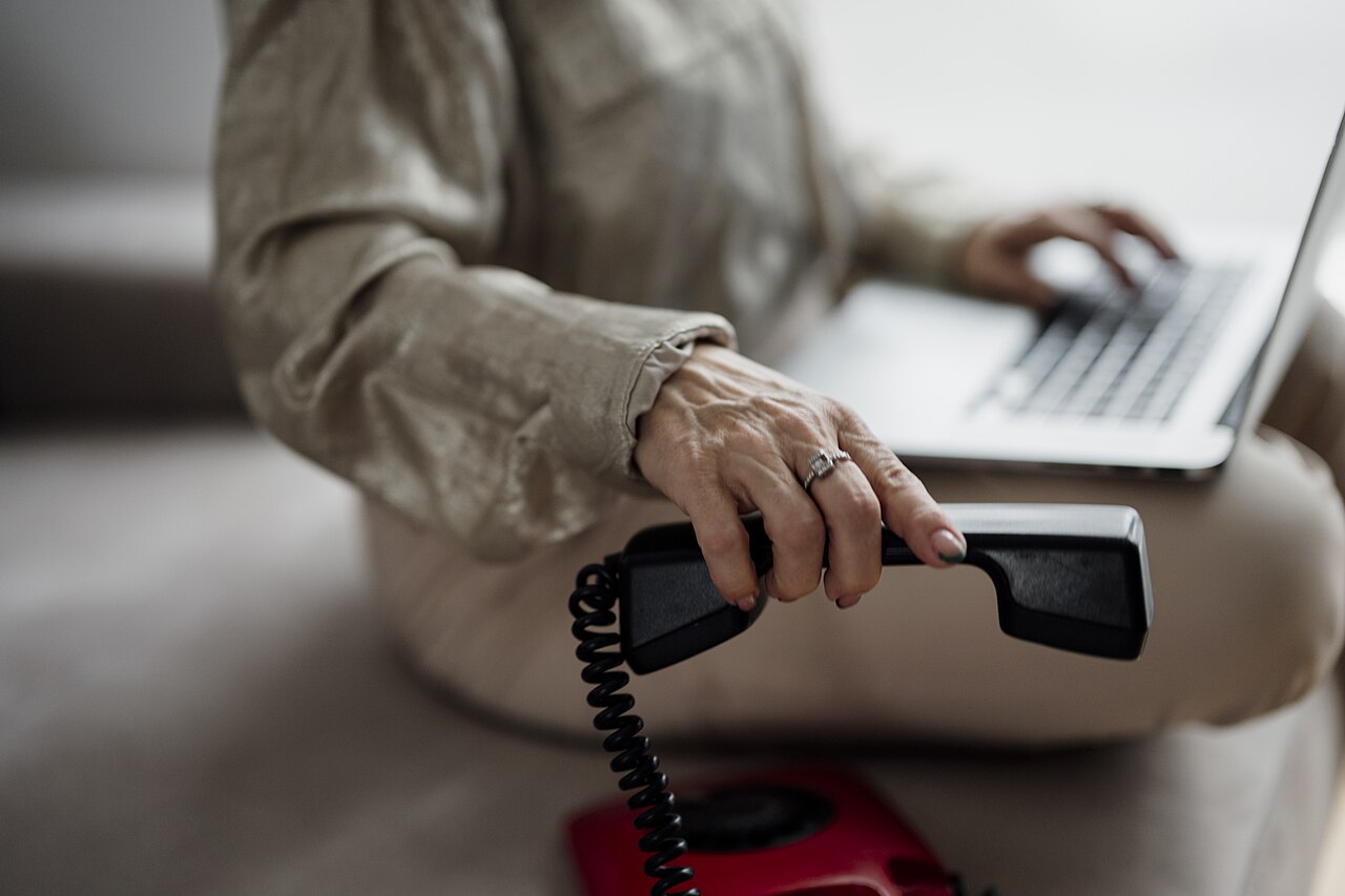 Person using a laptop while on the phone